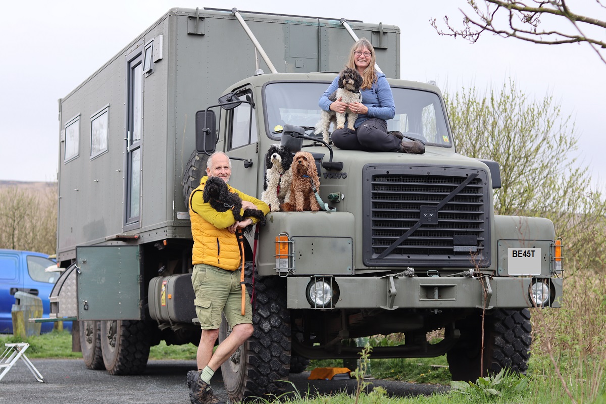 Author Jacqueline Lambert with husband Mark and four dogs sitting on The Beast, the huge volvo N10 ex army truck camper they built