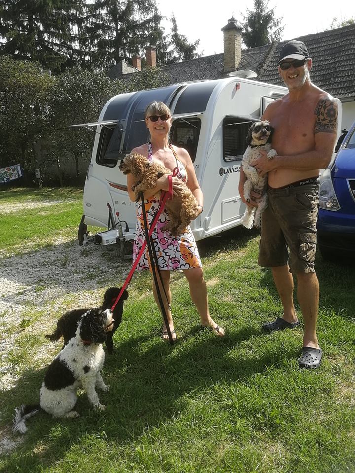 Author Jacqueline Lambert with husband Mark and four dogs in front of their Bailey Unicorn Vigo caravan