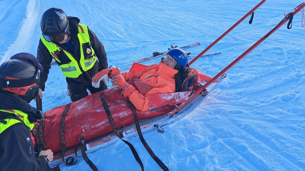 Mark being rescued on a blood wagon after breaking his leg skiing. At least he's still smiling!