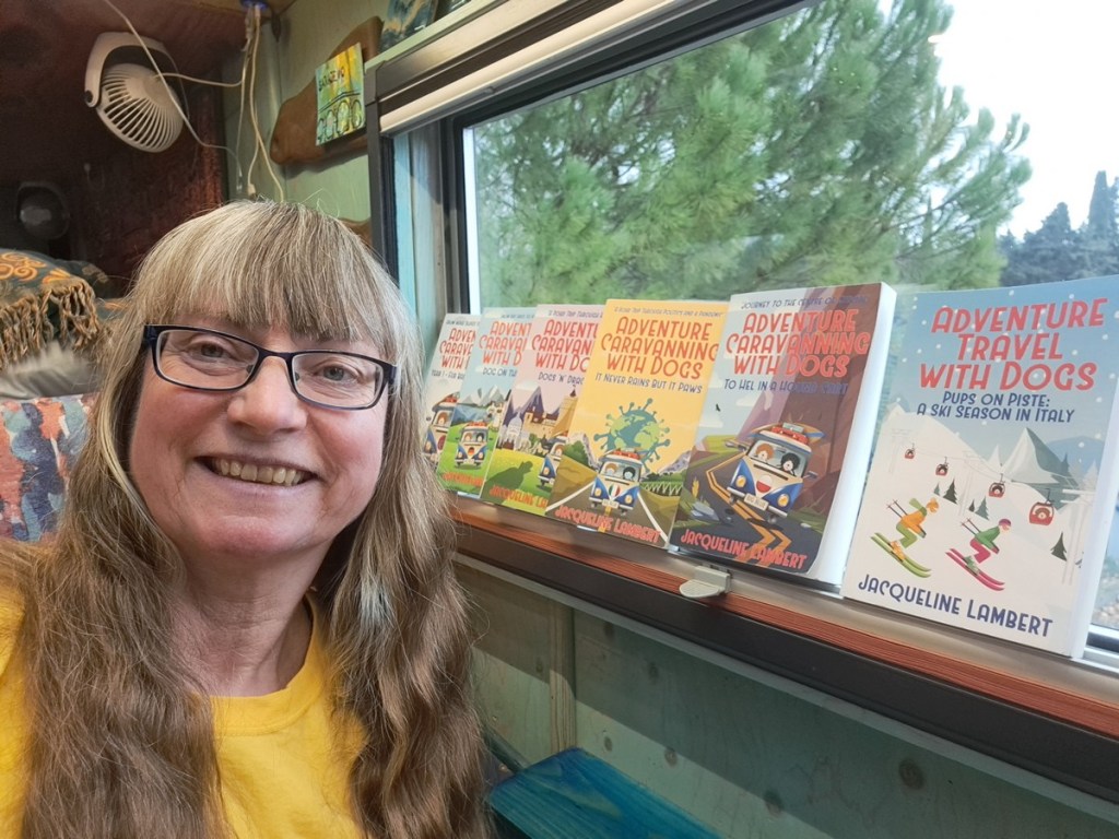 Headshot of Author Jacqueline Lambert with a few of her Adventure Caravanning With Dogs humorous Travel Memoirs