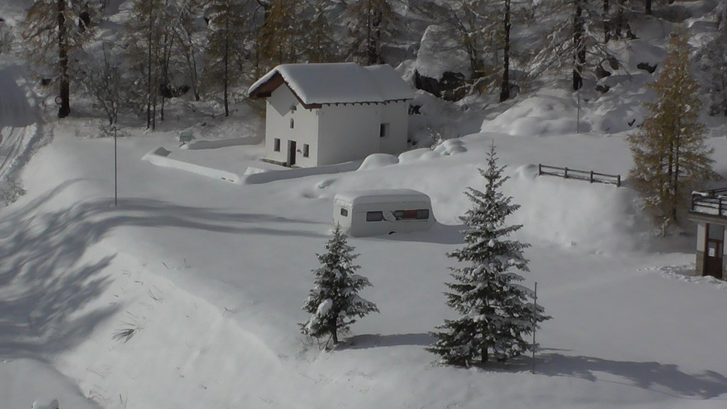 A snow covered Alpine landscape with Jacqueline Lambert author's caravan, Kismet, almost buried in the snow